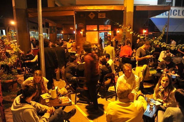 Bar Pinella com pessoas nas mesas durante a noite em Brasília